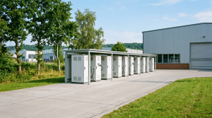 Großer Batteriespeicher-Schrank an der Außenwand einer norddeutschen Gewerbehalle bei hellem Tageslicht zur Lastspitzenkappung
