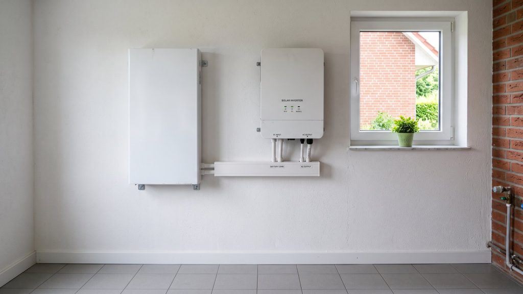 Nachgerüsteter PV-Speicher an der Wand eines hellen Hauswirtschaftsraums, direkt neben dem vorhandenen Wechselrichter.