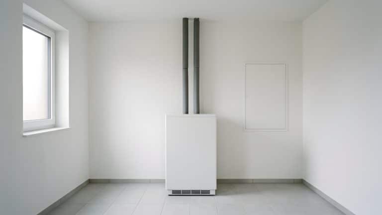 Hauswirtschaftsraum mit Wärmepumpen-Inneneinheit und moderner Elektroverteilung an der Wand